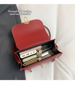 Spacious interior of red leather bag with gold hardware and daily essentials