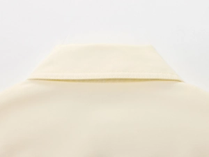 Close-up of the beige lapel collar showing precise single-stitch craftsmanship