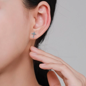 Retro sterling silver cross stud earring with blue turquoise inlay on model's ear