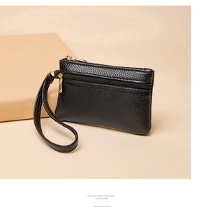 Close-up of double zipper mini coin purse in black lychee grain leather with wrist strap