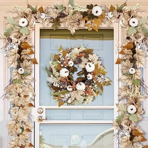 Close-up of fall garland featuring white pumpkins and maple leaves on a white door