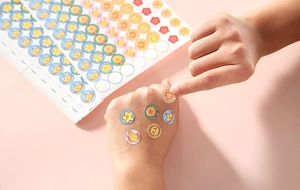 Close-up showing colorful cartoon reward stickers with sun and crown patterns for kids