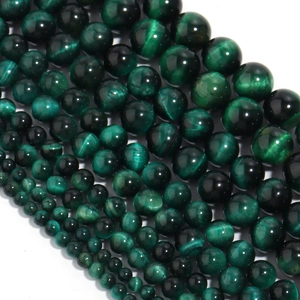 Macro shot of assorted green tiger eye stone beads in various sizes for DIY jewelry making
