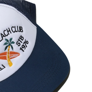 Close-up of palm tree embroidery and BEACH CLUB logo on white mesh trucker cap