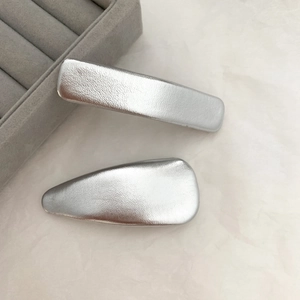 Detailed view of silver matte metallic hair clips in rectangular and drop shapes