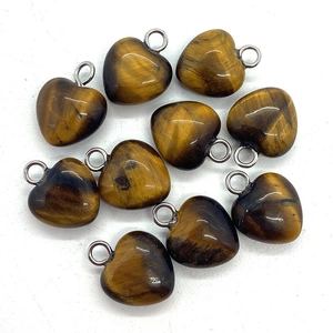 Set of ten 10mm heart-shaped tiger eye stone pendants with metal bail on white background