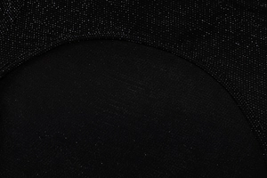 Détail du tissu en maille noire avec paillettes argentées et coutures lisses