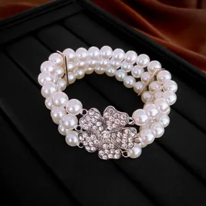 Three-layer pearl bracelet with a sparkling rhinestone clover charm on black leather