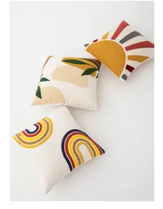 Close-up of velvet cushion covers featuring colorful rainbow and sun tufted embroidery