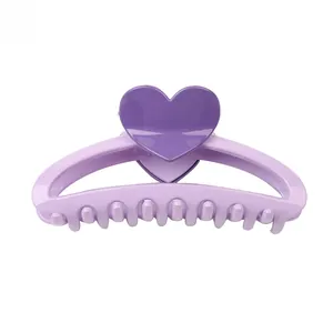 Detailed view of sweet heart-shaped hair claw clip in purple tones with glossy finish