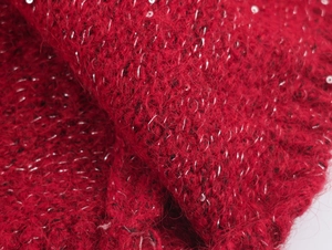 Vue détaillée du tricot mohair rouge foncé avec des paillettes argentées et fils brillants