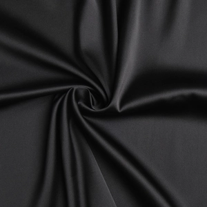 Gros plan sur le tissu en satin noir élégant avec une texture soyeuse et des reflets