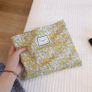 Close-up of floral makeup bag with leaf pattern and Time to Party woven label