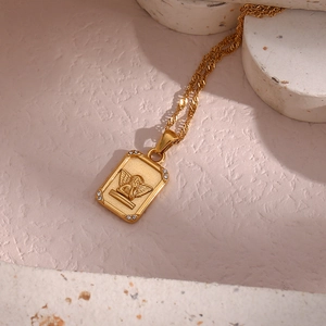Macro detail of golden angel pendant with sparkling zircons and water wave chain