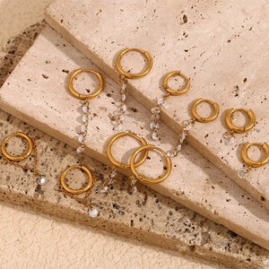 18K gold plated stainless steel hoop earrings with white zircon tassels on travertine stone