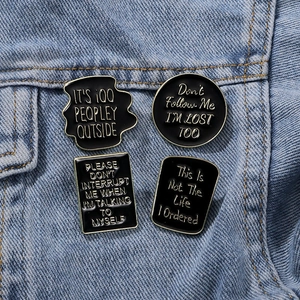 Set of four black enamel badges with gold plating on denim, retro punk style pins