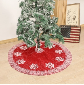 Top view of a red knitted Christmas tree skirt with white snowflake patterns and plush trim