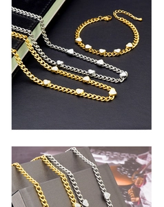 Detail of crystal heart pendant and Cuban chain in gold and silver finishes
