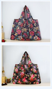 Close-up of two foldable floral shopping bags with blue and black rose patterns