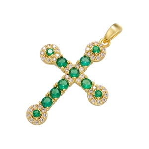 Gold cross pendant with vibrant green zircons and sparkling clear stones on white backdrop