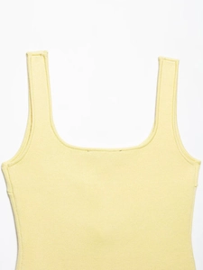 Detailed close-up of light yellow flat-knit camisole bodice with smooth shoulder straps