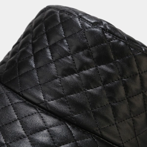 Detailed close-up of quilted black leather texture on a fashion bucket hat crown