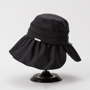 Close-up of black wide-brim sun hat with wavy ruffles and metallic logo detail