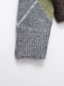 Detailed close-up of argyle knit sweater cuff featuring grey ribbing and fuzzy mohair texture