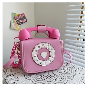 Detail of pink vintage telephone-shaped handbag with rotary dial and heart decoration