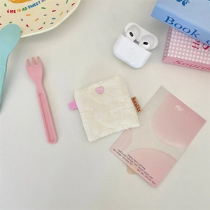 Detail of cream quilted small organizer pouch with heart texture and pink heart button