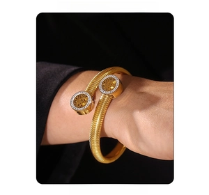 Detail of 18k gold plated tree of life bangle with crystals and snake bone texture