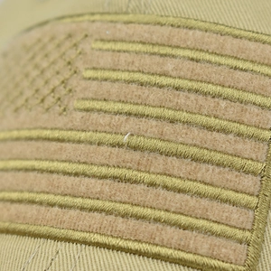 Detailed macro view of embroidered American flag patch on washed cotton tactical baseball cap