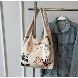 Detail of canvas tote bag featuring cute animal illustrations and artistic typography