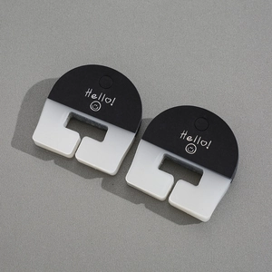 Detail of black and white cable organizers with Hello! text on a grey surface