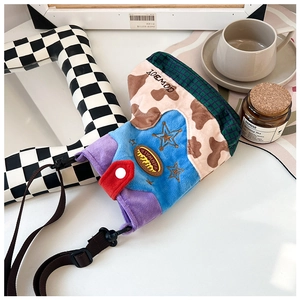 Detail of a quirky cowboy boot shaped nylon crossbody bag with colorful plush patchwork