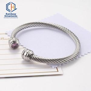 Detailed macro view of silver twisted cable bracelet with a round purple gemstone inlay