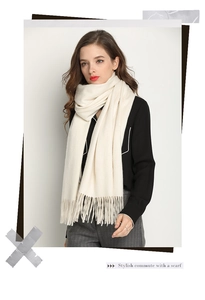 Close-up of soft beige cashmere-like scarf with fringe detail in a stylish commute style