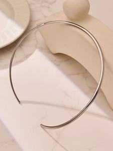 Collier ras du cou argenté minimaliste sur fond élégant en marbre et céramique