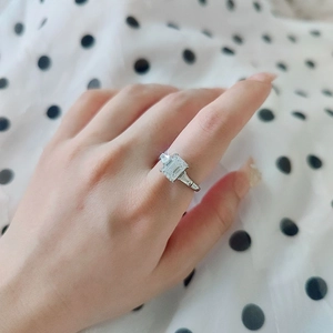 Macro shot of a 2ct emerald cut moissanite ring with side baguette stones on a silver band