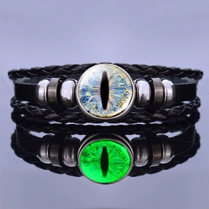 Detailed view of luminous dragon eye leather bracelet with glowing green effect in dark