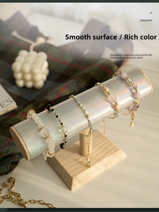 Close-up of wooden bracelet display stand with iridescent pillar and beaded jewelry