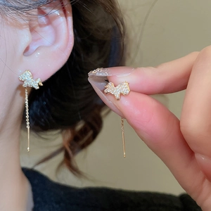 Detail of gold-plated unicorn drop earrings featuring sparkling crystals and long chains