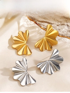 Vue détaillée de boucles d'oreilles ondulées en métal doré et argenté sur tissu en soie