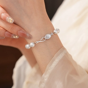 Close-up of elegant pearl bracelet with silver clasp and mother of pearl inlay on wrist