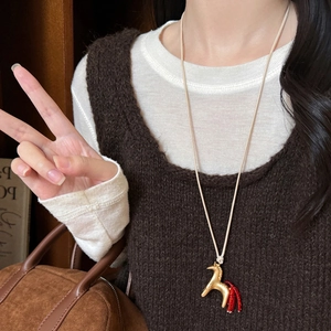 Fashionable golden horse pendant necklace with red bead tassel on a woven cord lanyard
