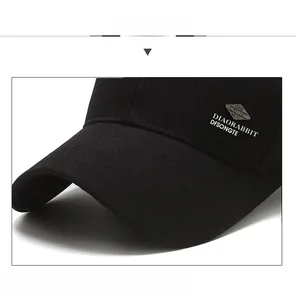 Detailed close-up of the reinforced brim and metal logo on this black cotton baseball cap