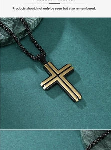 Detailed macro view of a two-tone black and gold cross pendant with a twisted chain