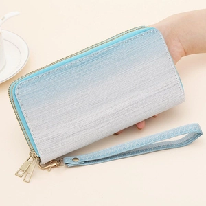 Detail of gradient blue double zipper clutch purse with woven texture and wrist strap