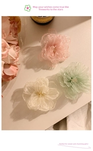 Detailed macro view of 3D layered organza fabric flowers in pink, mint green and cream