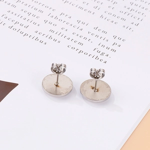 Detail view of round silver stainless steel stud earring backs with butterfly stoppers